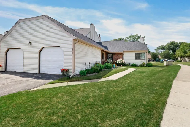 a front view of a house with a garden and plants