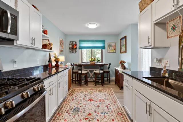 a kitchen with granite countertop a sink stove and cabinets