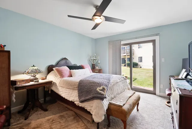 a spacious bedroom with a bed and wooden floor