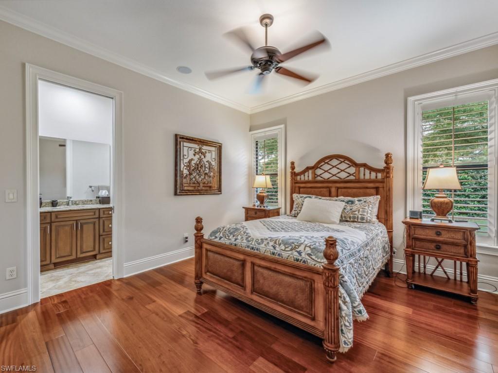 16509 Cellini Lane Naples, FL 34110 - Photo 16 of 49 a bedroom with a bed a chandelier and dresser