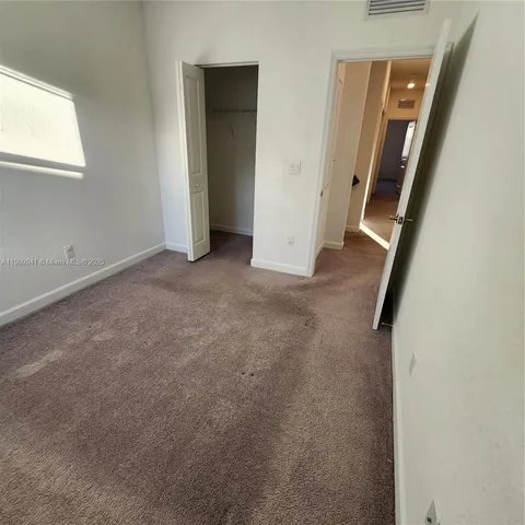 an empty room with mirror and door