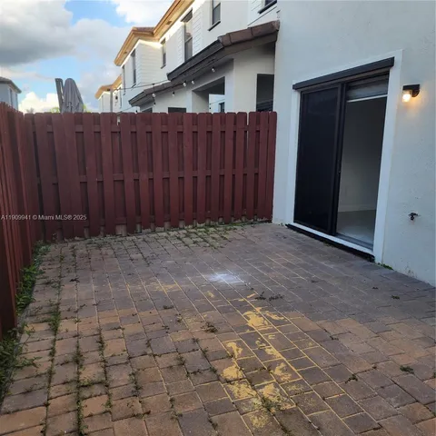 a view of backyard with wooden fence