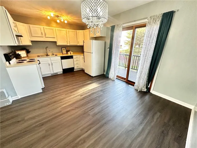 a view of a kitchen with furniture and wooden floor
