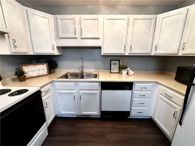 a kitchen with stainless steel appliances white cabinets sink and stove