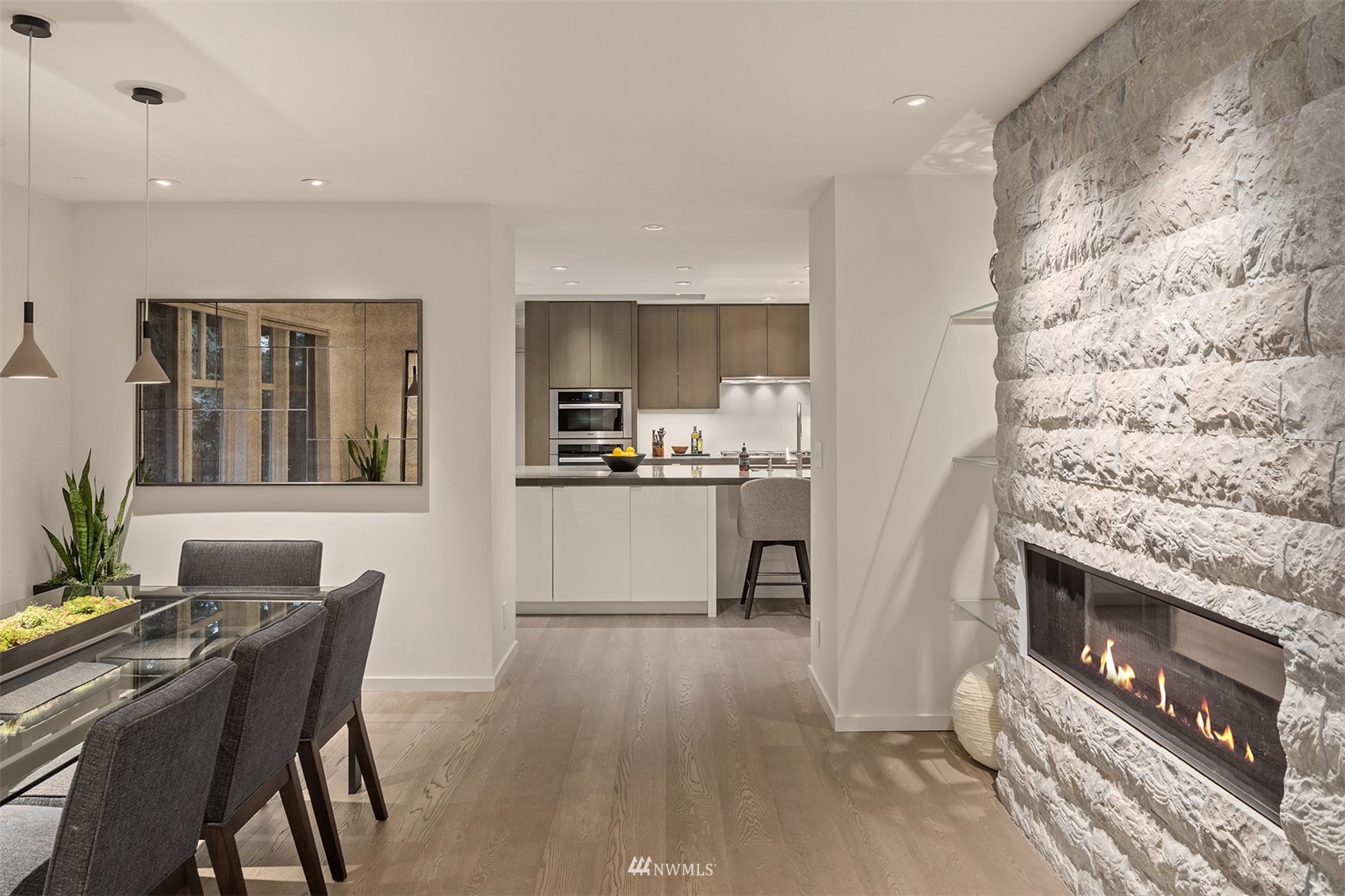3022 Hunts Point Road Hunts Point, WA 98004 - Photo 12 of 37 a kitchen with stainless steel appliances kitchen island granite countertop a stove a sink a refrigerator and a dining table with wooden floor