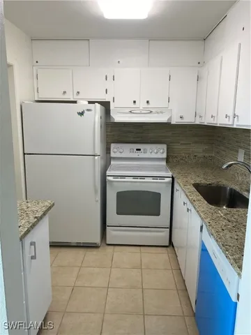 a kitchen with a stove top oven sink and cabinets