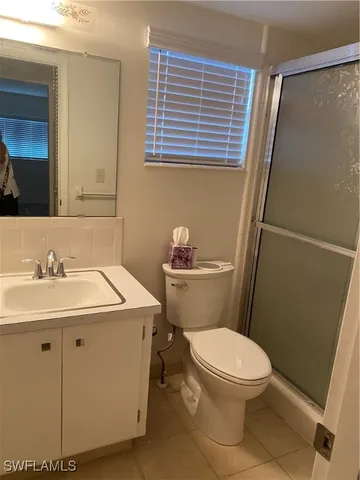 a bathroom with a sink a toilet a mirror and shower