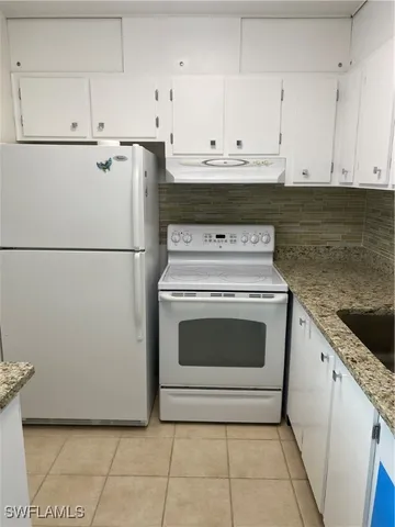a kitchen with white cabinets and white appliances