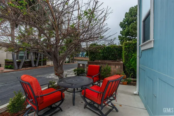 a kitchen with stainless steel appliances granite countertop a refrigerator a stove a sink and a dining table with wooden floor