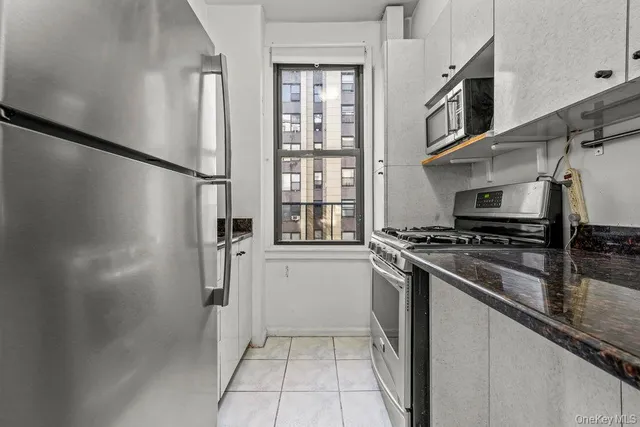 a kitchen with stainless steel appliances granite countertop a refrigerator and a stove