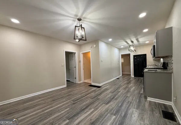 a kitchen with granite countertop a refrigerator oven a sink dishwasher and wooden floor