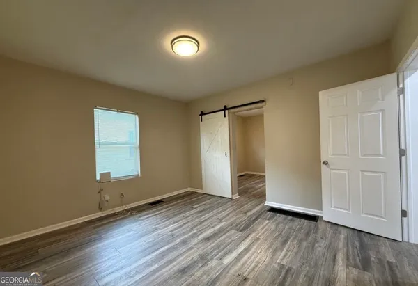 an empty room with wooden floor and a window