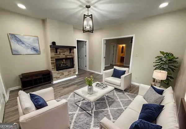 a living room with furniture a chandelier and a flat screen tv