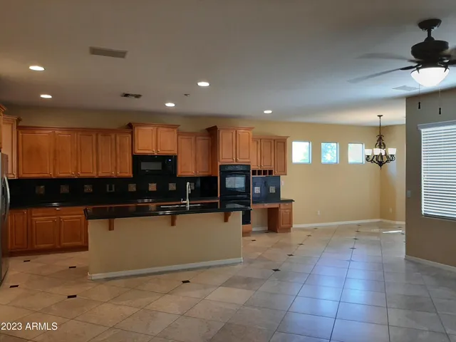 a kitchen with stainless steel appliances granite countertop a refrigerator a stove a sink a microwave and cabinets