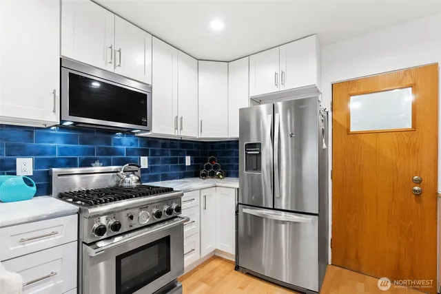 a kitchen with stainless steel appliances a refrigerator stove and microwave