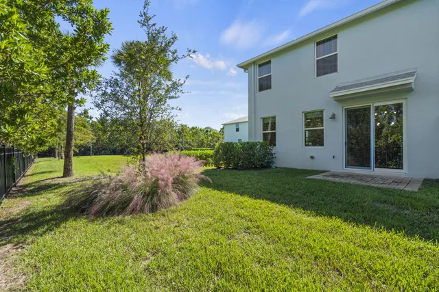 a view of a house with backyard and a tree