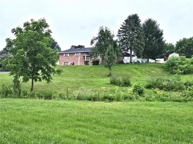 a front view of a house with a garden and trees