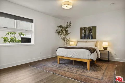 a bed sitting in a bedroom next to a window