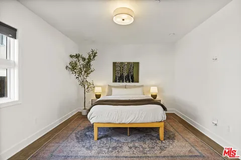 a bedroom with a bed and a potted plant