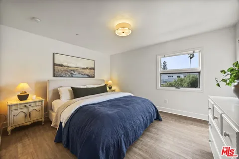 a bedroom with a bed and a painting on the wall