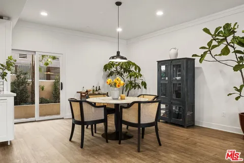 a dining room with furniture potted plants and wooden floor