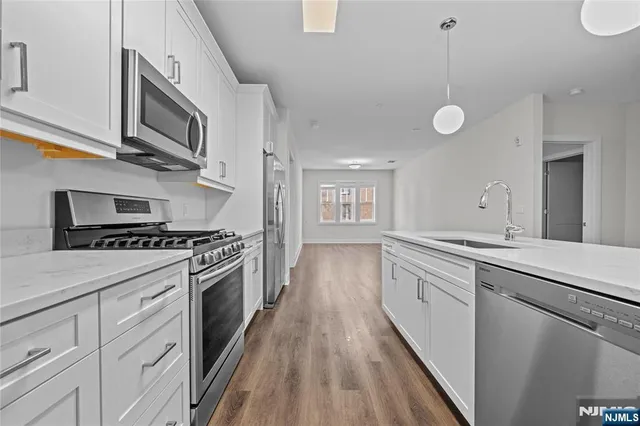 a kitchen with stainless steel appliances a sink stove and cabinets