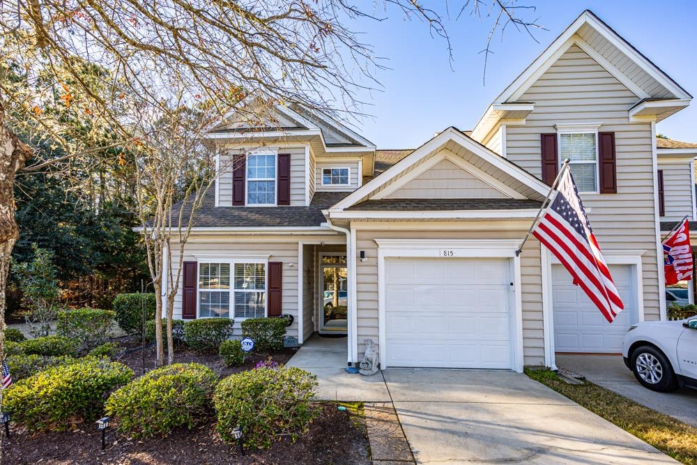 View of front of house with concrete driveway, a garage, and roof with shingles
