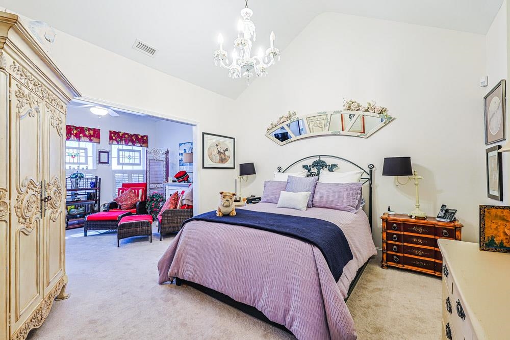 815 Botany Loop, Unit 815 Murrells Inlet, SC 29576 - Photo 12 of 40 Bedroom with lofted ceiling, light carpet, and a chandelier