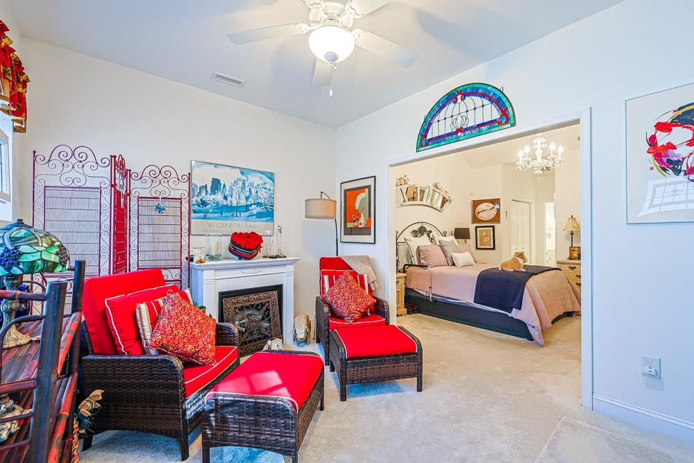 815 Botany Loop, Unit 815 Murrells Inlet, SC 29576 - Photo 14 of 40 Bedroom featuring carpet, ceiling fan, a chandelier, and a fireplace