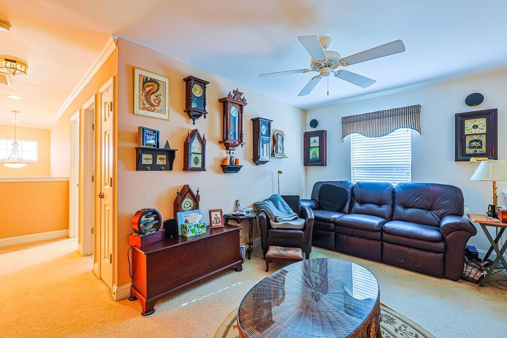 815 Botany Loop, Unit 815 Murrells Inlet, SC 29576 - Photo 23 of 40 Living area featuring carpet flooring, a chandelier, and ceiling fan