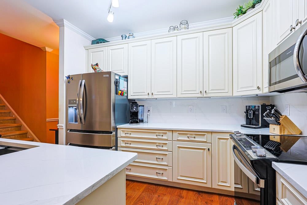 815 Botany Loop, Unit 815 Murrells Inlet, SC 29576 - Photo 9 of 40 Kitchen with stainless steel appliances, light wood-style floors, light stone countertops, and crown molding