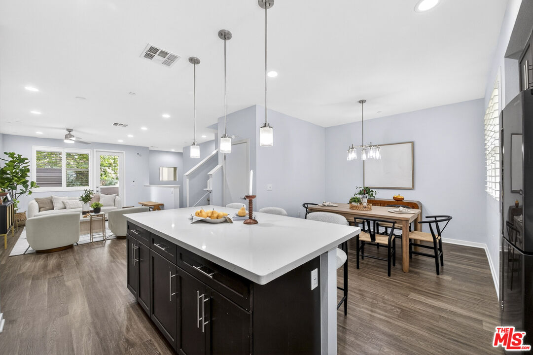 676 Colorado Circle Carson, CA 90745 - Photo 13 of 36 a kitchen with a stove a counter space wooden floor and a chandelier
