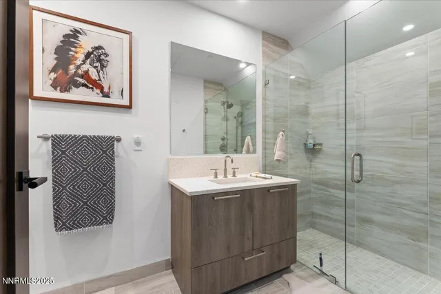 a bathroom with a sink a mirror and a shower