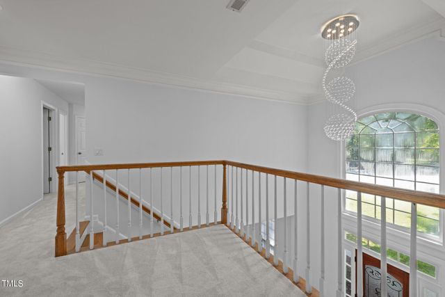 a view of staircase with railing and a chandelier