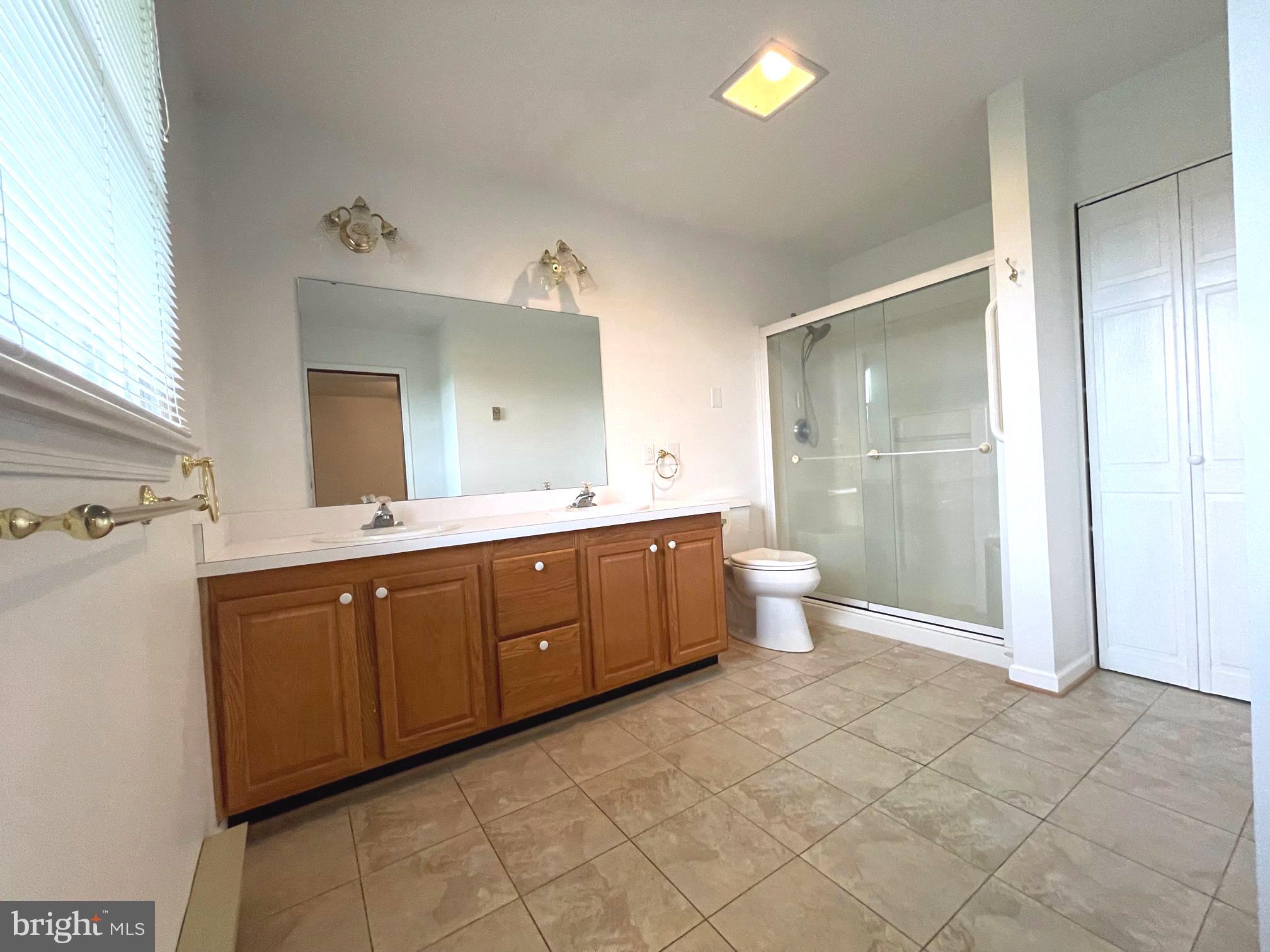 21133 Foxcroft Road Middleburg, VA 20117 - Photo 23 of 41 a spacious bathroom with a double vanity sink a toilet a mirror and a shower