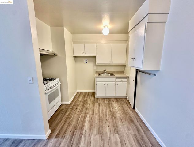a kitchen with white cabinets and white appliances