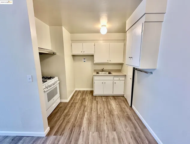 a kitchen with white cabinets and white appliances