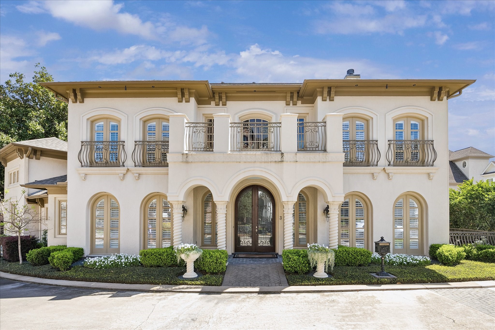 a view of a white house with large windows and a clock tower in front of it