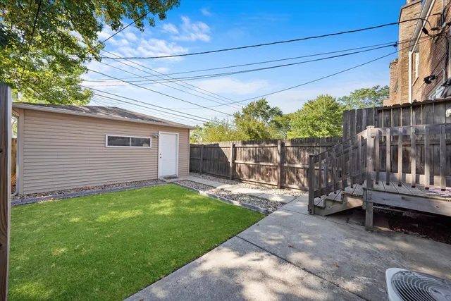 a view of a backyard with wooden fence and a bench