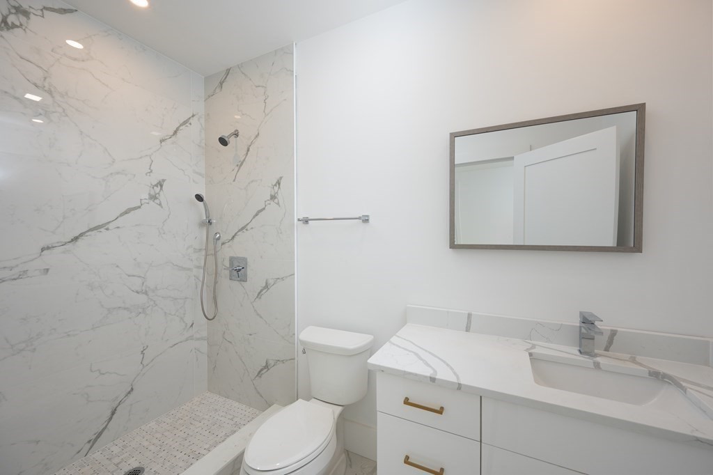 9 Greenmount Street, Unit 2 Boston, MA 02125 - Photo 11 of 15 a bathroom with a toilet sink vanity granite and shower