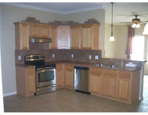 a kitchen with granite countertop a stove a sink and a microwave