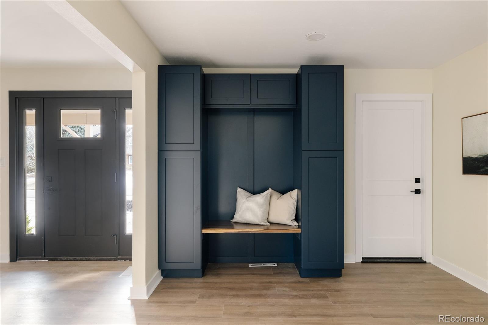 7580 South Lost Ranger Peak Littleton, CO 80127 - Photo 28 of 34 a room with a bench and a wooden floor