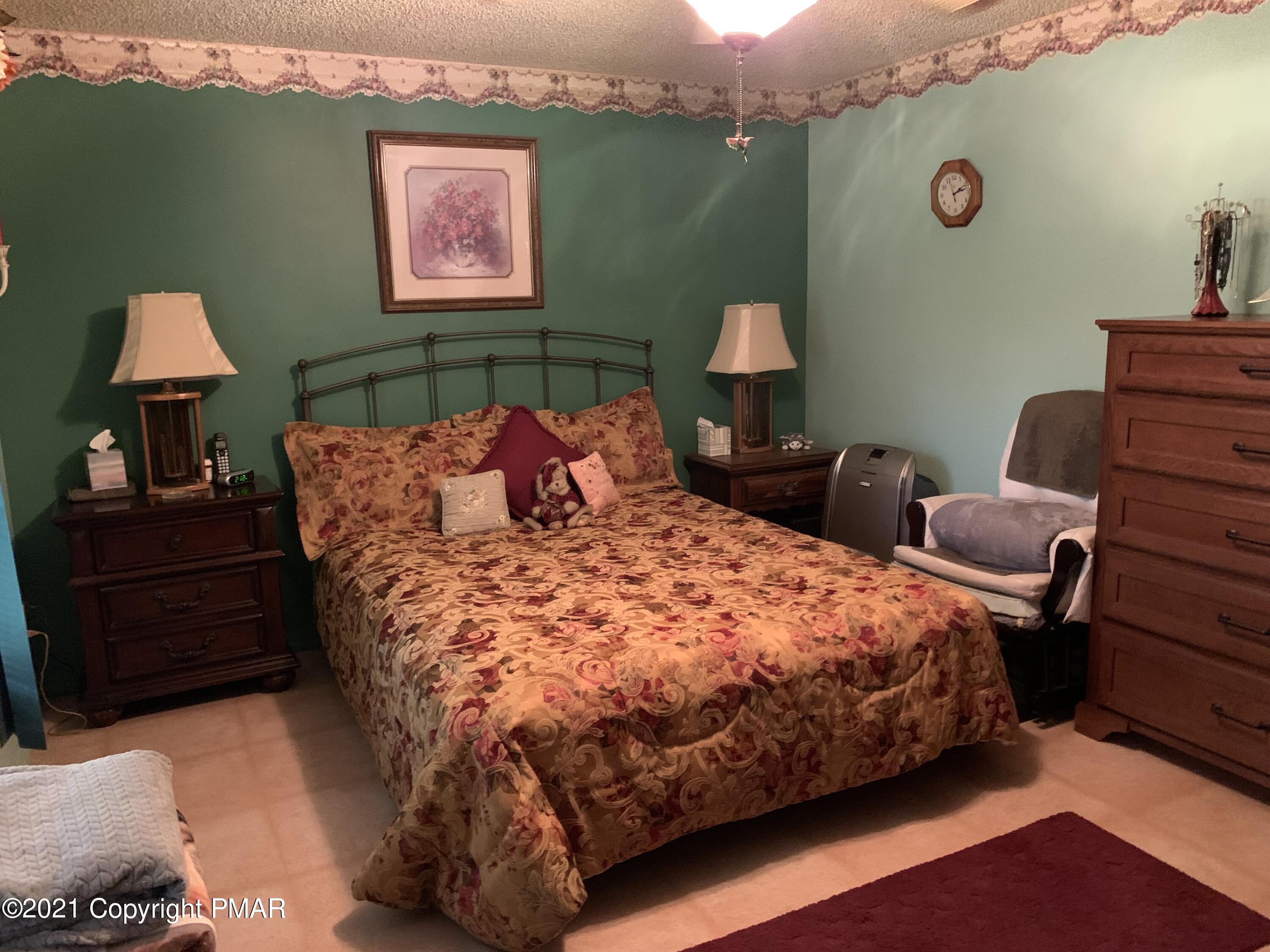 338 Laurel Lake Road Bartonsville, PA 18321 - Photo 20 of 27 a bed sitting in a bedroom next to a lamp