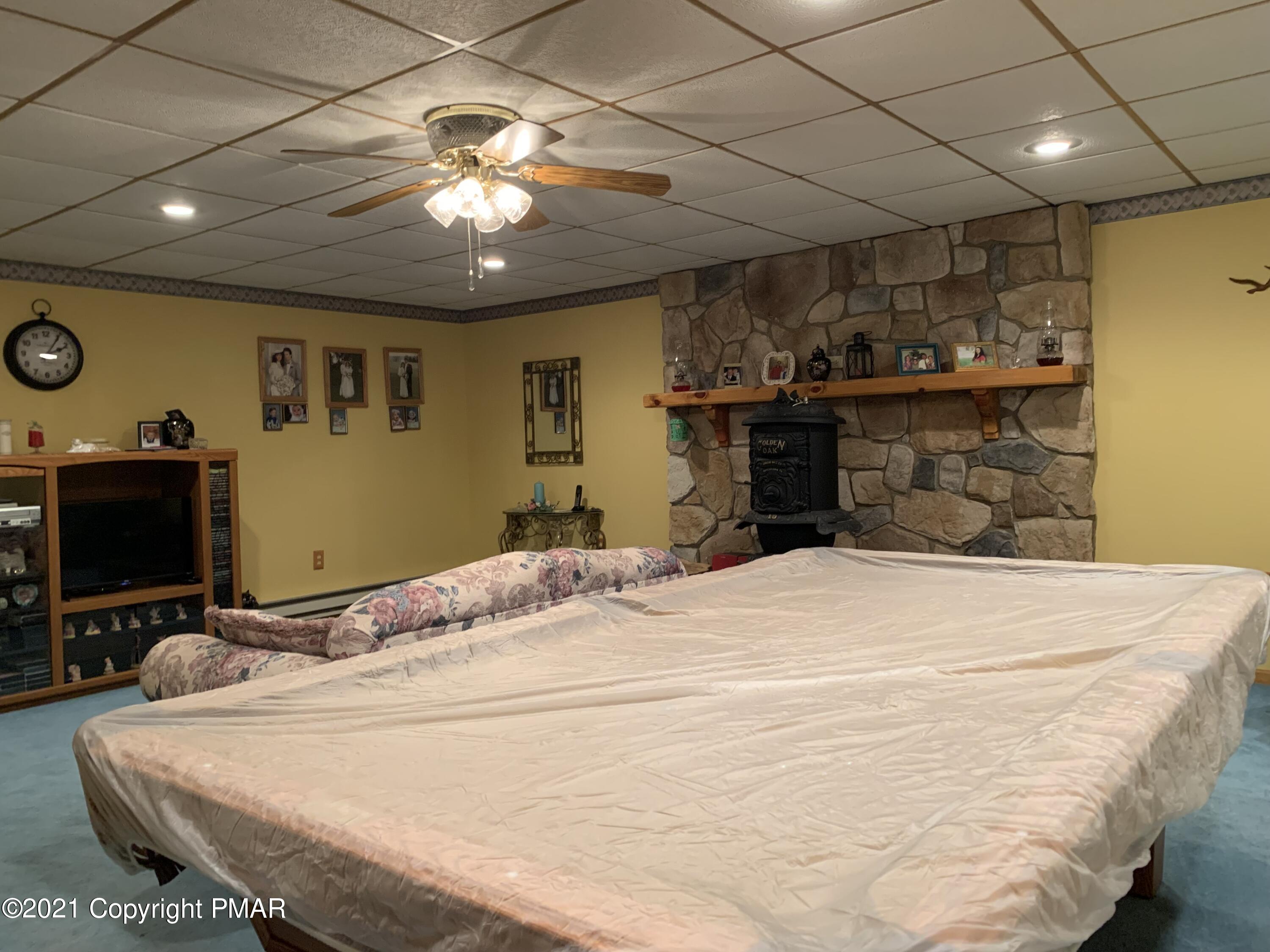 338 Laurel Lake Road Bartonsville, PA 18321 - Photo 9 of 27 a bedroom with a bed and a chandelier