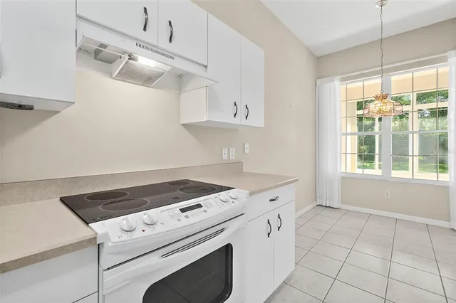 a kitchen with white cabinets and appliances