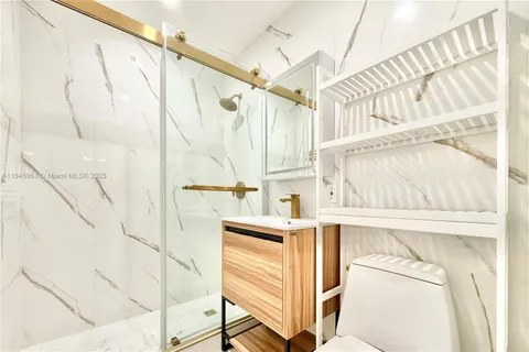 a view of walk in closet with clothes and white wooden floors