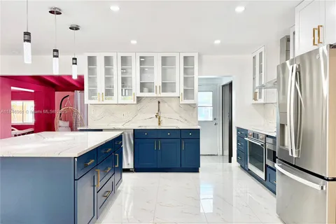 a kitchen with stainless steel appliances granite countertop a refrigerator and a sink