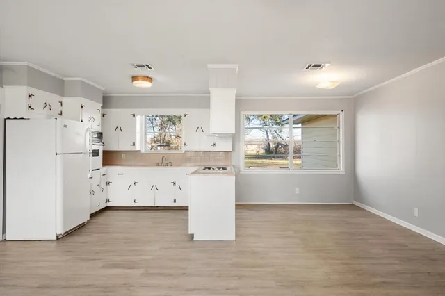 a kitchen with stainless steel appliances a refrigerator sink and white cabinets