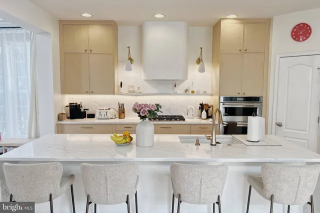 a kitchen with a sink a refrigerator and chairs