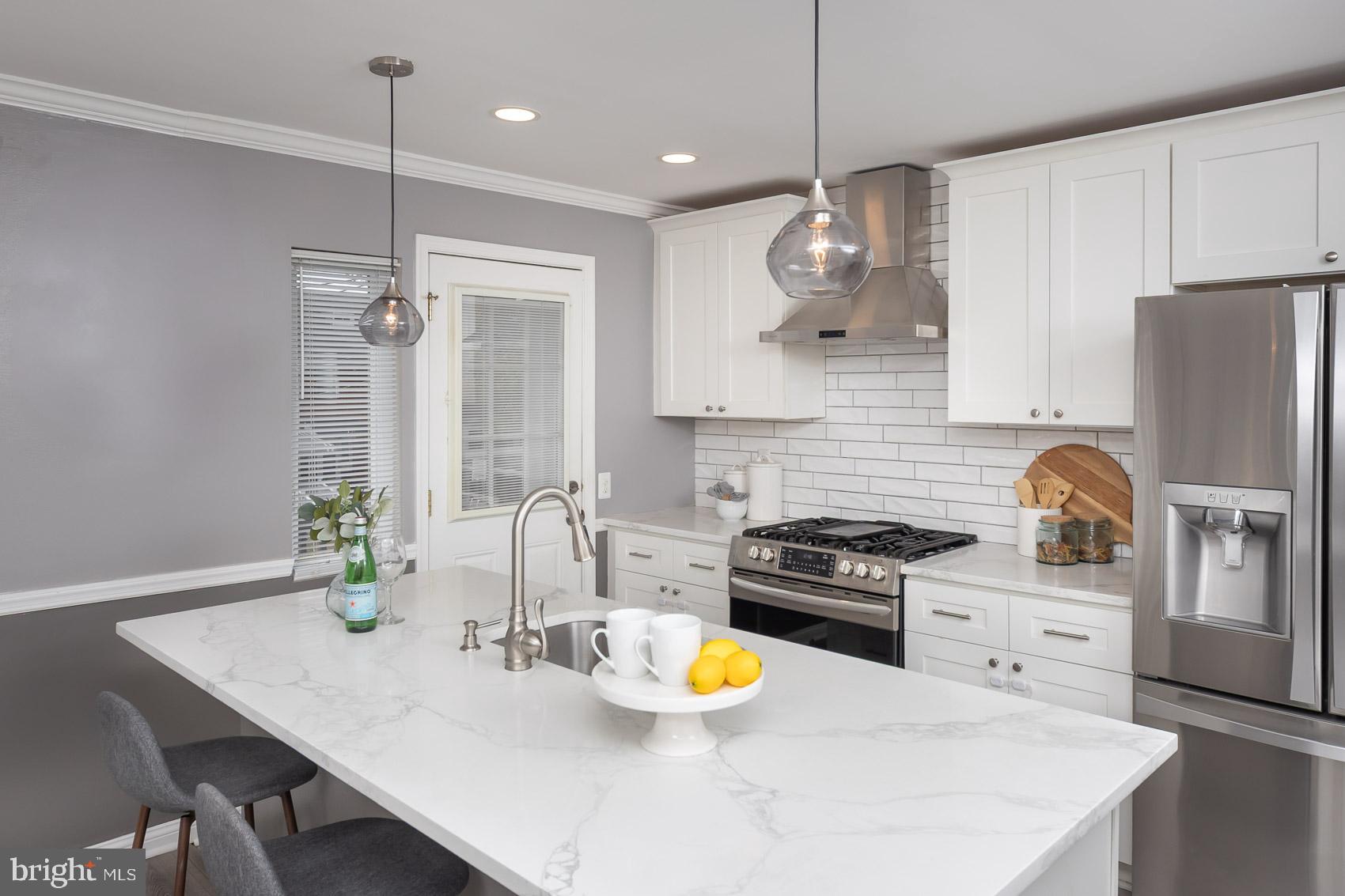 1809 Northbourne Road Baltimore, MD 21239 - Photo 16 of 43 a kitchen with stainless steel appliances a table chairs and a refrigerator